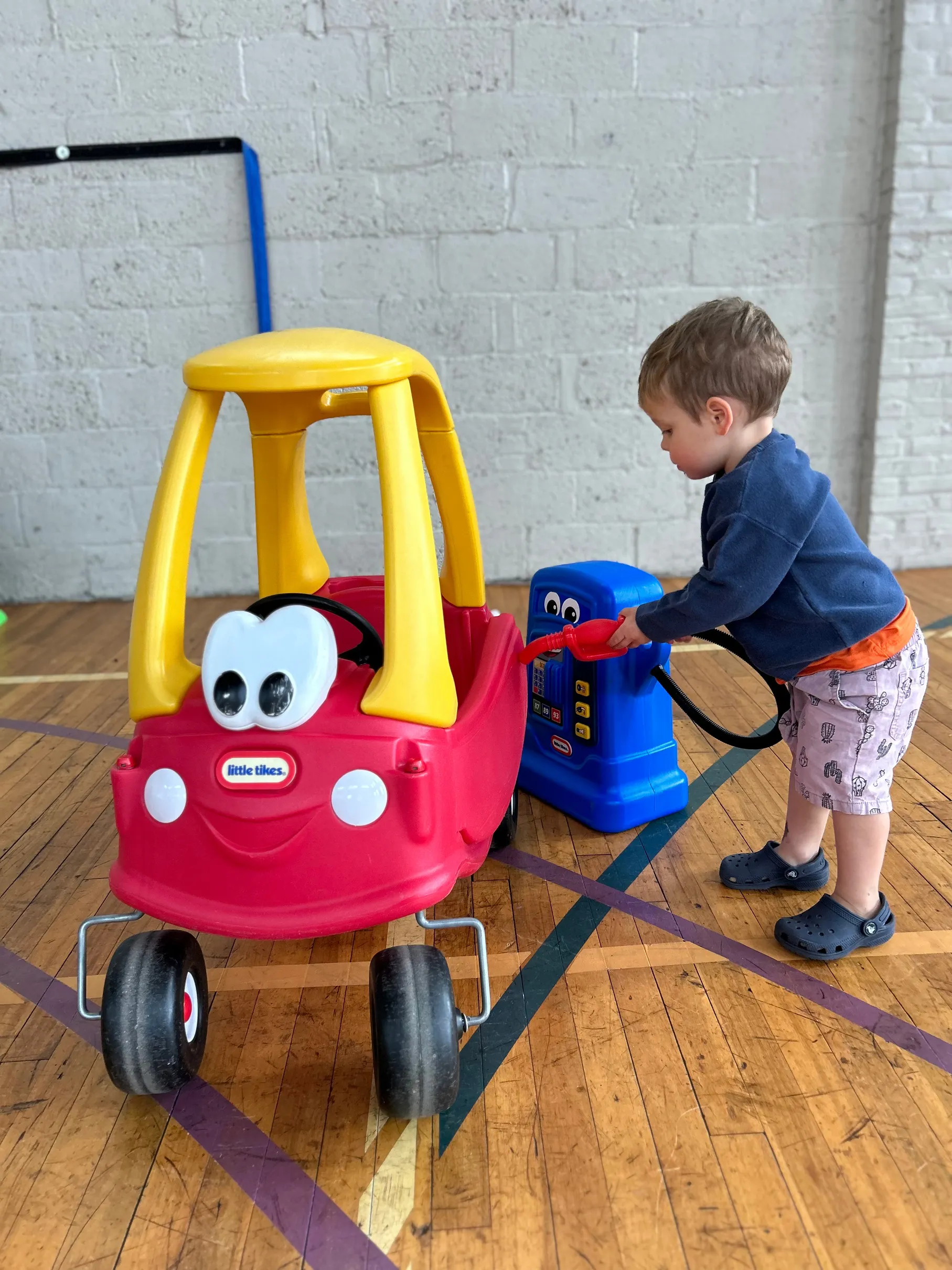 Picture of a young boy playing with red little tikes car at Tot Spot Lancaster.